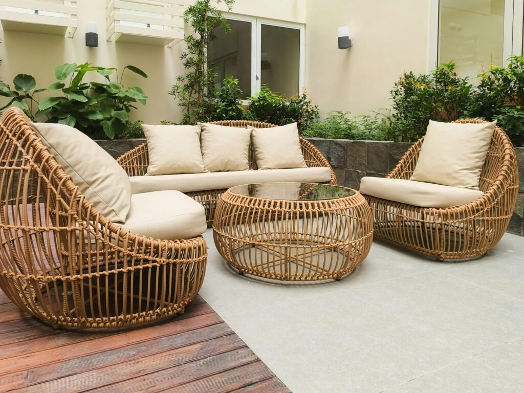 pexels-photo-27975920-27975920 Outdoor seating with rattan furniture set in a lush garden patio, ideal for relaxation and gatherings.